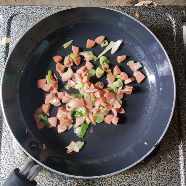 Masukkan irisan sosis dan daun bawang, masak hingga matang