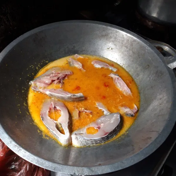 Masukkan ikan yang telah dipotong, masak agak lama hingga matang lalu koreksi rasa.