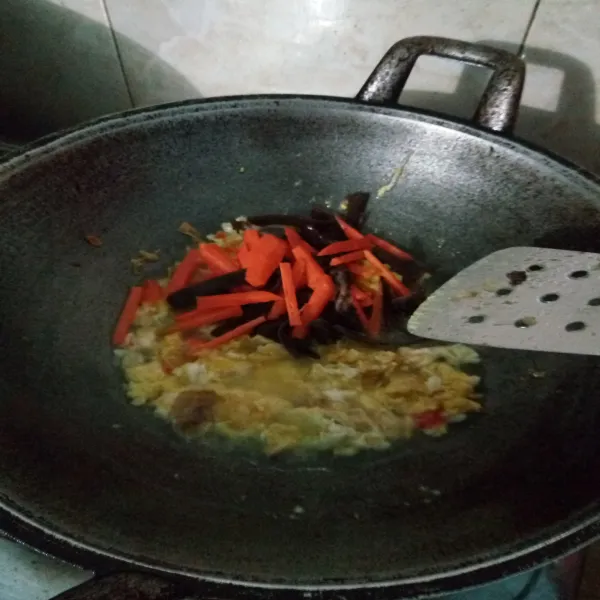 Tambahkan 50 ml air. Kemudian masukkan wortel dan jamur kuping. Masak hingga sayur layu.