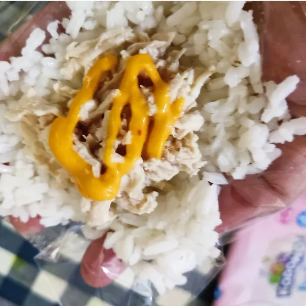 Ambil secentong nasi, tambahkan tuna oil di tengahnya beri sedikit mayonaise bila suka, tutup kembali dengan nasi dan kepal-kepal hingga padat