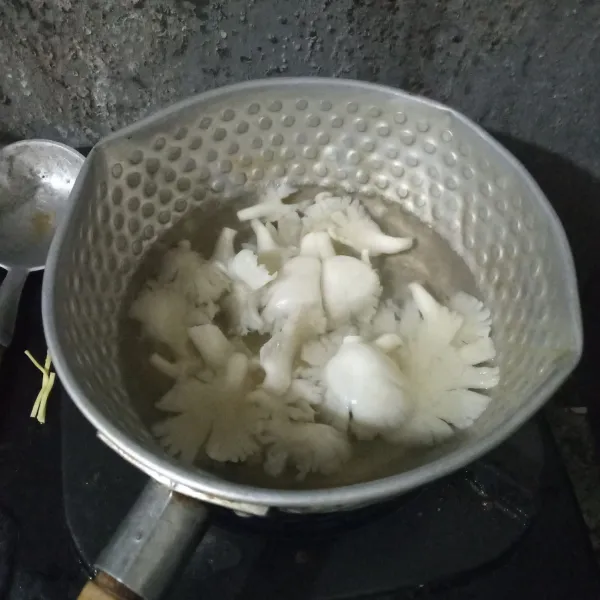 Rebus jamur tiram selama 5 menit, tiriskan dan peras airnya.