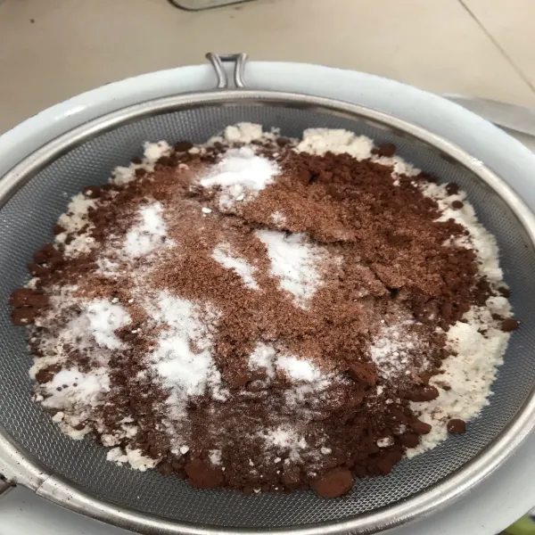 Kocok telur dan gula hingga gula larut. Masukkan vanili dan SKM, aduk rata kembali. Ayak tepung, coklat bubuk, baking powder dan baking soda, lalu masukkan ke dalam adonan. Aduk rata kembali.