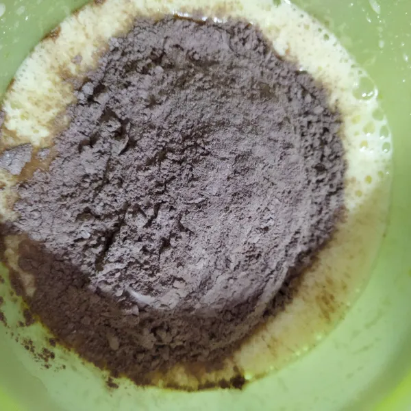 Tambahkan tepung terigu, coklat bubuk, baking powder dan baking soda yang sudah diayak. Aduk rata.