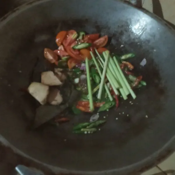 Masukkan tomat, serai, daun salam, gula, garam dan lengkuas. Aduk rata, masak hingga bumbunya luntur.