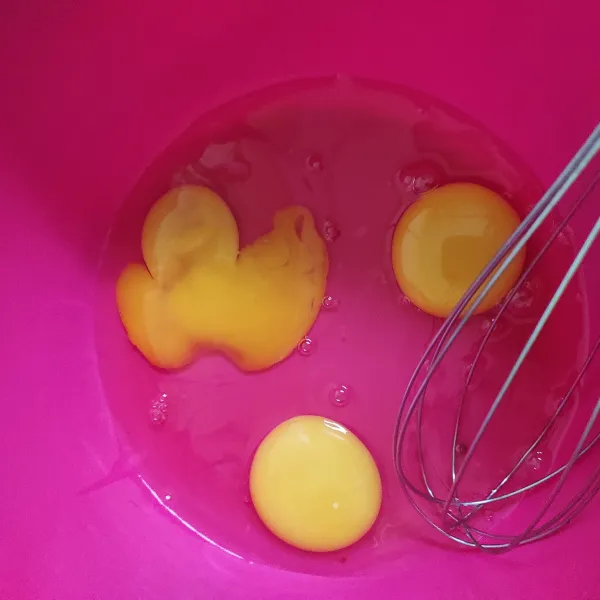 Dalam wadah, kocok telur asal rata.
