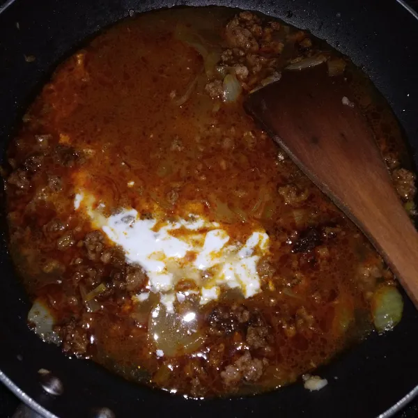 Masukkan bumbu rendang, air dan santan. Biarkan mendidih.