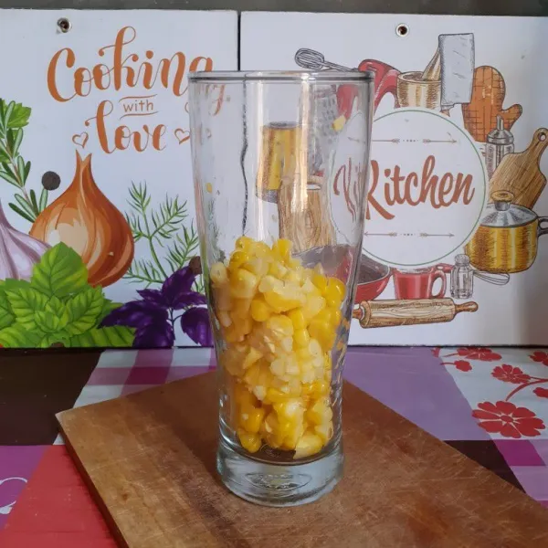 Serut jagung menggunakan pisau. Masukkan setengah bagian ke dalam gelas saji.