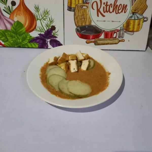 Ambil sebagian bumbu kacang dan taruh dalam piring saji. Masukkan lontong dan tahu goreng yang sudah di iris.