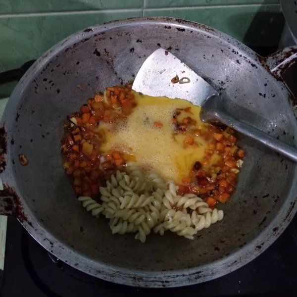 Masukkan telur kocok dan fusilli, lalu buat orak-arik.