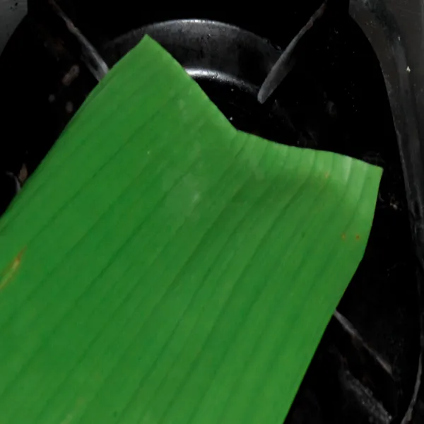 Siapkan daun pisang dan panggang daun pisang sebentar saja supaya daunnya mudah untuk di lipat dan tidak sobek.