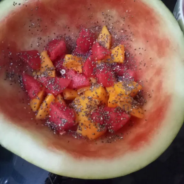 Masukkan potongan buah ke dalam batok semangka. Taburkan chia seed. Lalu tuang agar-agar ke dalam batok semangka.