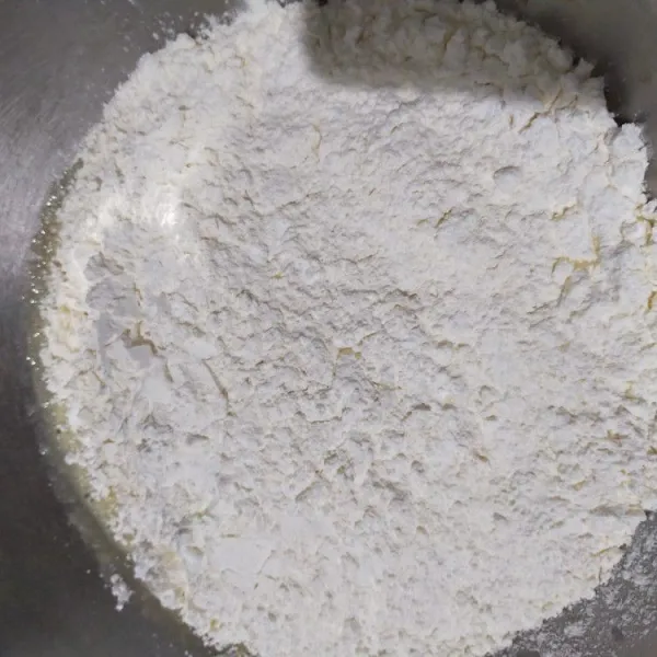 Masukkan tepung maizena, tepung terigu, susu bubuk, dan baking powder, lalu aduk rata.