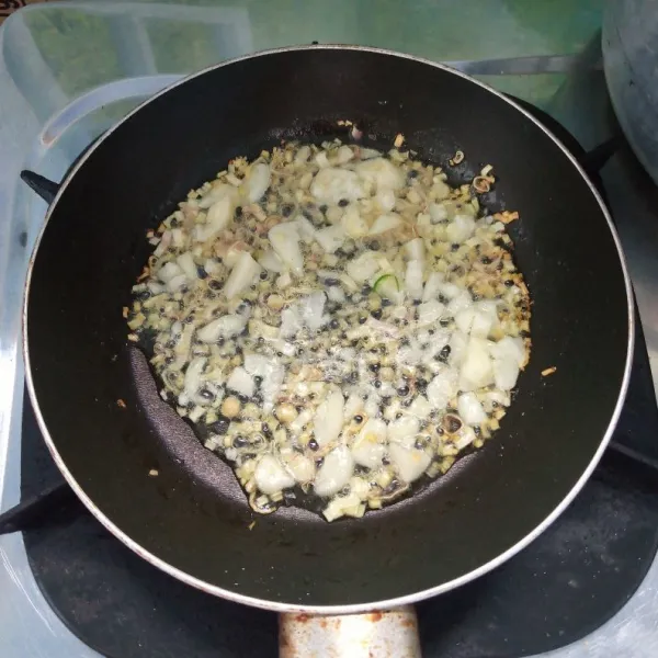 Panaskan minyak goreng, masukkan serai, lalu aduk rata. Tambahkan bawang putih dan terasi, aduk rata. Masak sebentar.