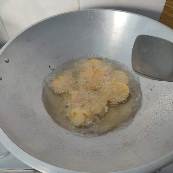 Kupas kulit kentang, lalu cuci bersih, kemudian potong selebar 1 cm dan goreng hingga matang. Kemudian tiriskan.