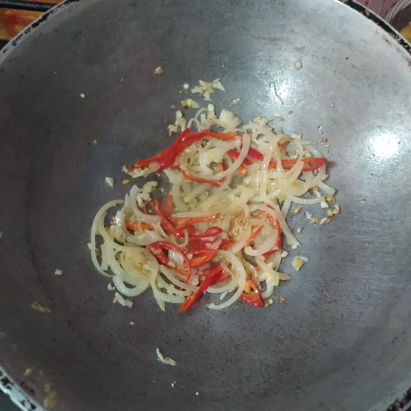 Membuat saus asam manis tumis bawang bombay hingga layu, lalu masukkan bawang putih cincang. Masukkan cabai merah besar.