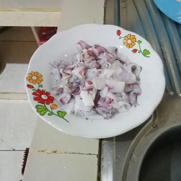 Buang tinta dan plastik cumi. Bilas hingga bersih lalu potong-potong.