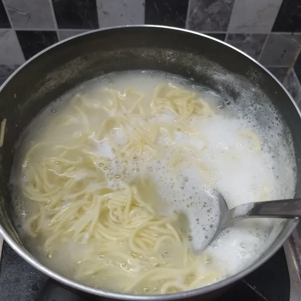 Sisa air merebus telur gunakan untuk memasak mie sampai matang, lalu angkat dan tiriskan. Tambahkan 1 sdm minyak goreng, lalu aduk rata dan sisihkan.