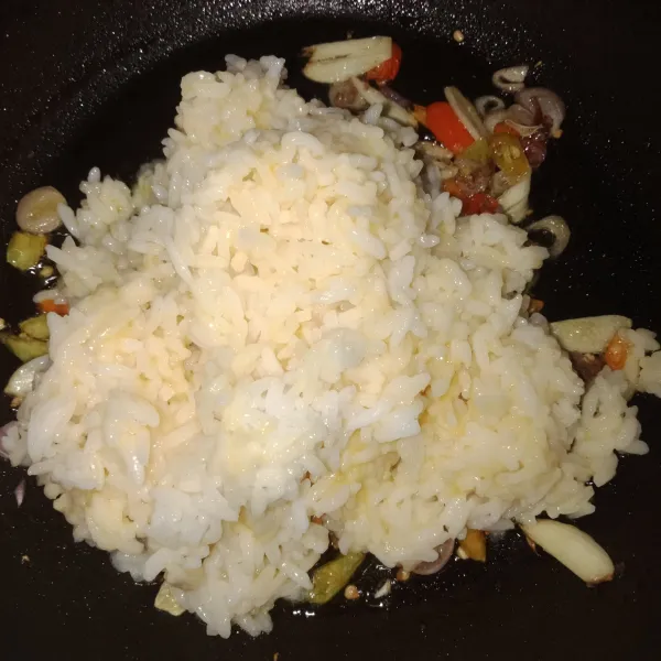 Masukkan nasi yang sudah dicampur dengan telur, tambahkan garam dan kaldu bubuk.