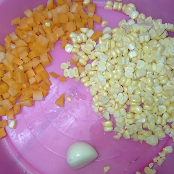 Pipil jagung manis, potong dadu kecil wortel, dan cincang halus bawang putih.