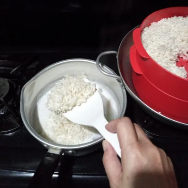 Masukkan beras ketan ke dalam santan, lalu aduk rata.