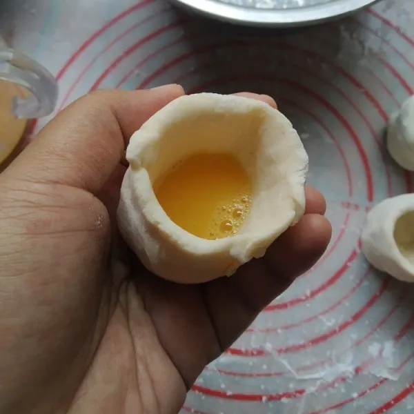 Isi dengan kocokan telur hingga 2/3 bagian, jangan terlalu penuh agar tidak bocor.