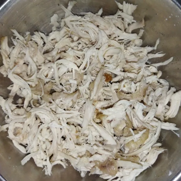Siapkan 1/4 ekor daging ayam, rebus hingga empuk, lalu goreng sebentar, kemudian suwir-suwir.