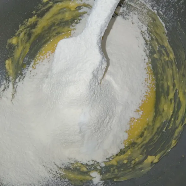 Masukkan tepung terigu dan baking soda sambil di ayak, lalu aduk rata.