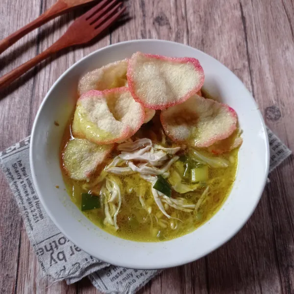 Tata nasi, bihun, ayam dan kerupuk lalu beri kecap manis dan tuang air soto. Sajikan selagi hangat.