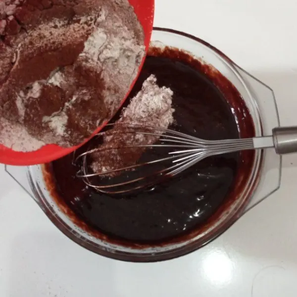 Kemudian masukkan tepung terigu dan cokelat bubuk, lalu aduk rata.