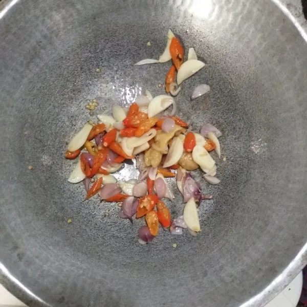 Tumis jahe, bawang merah, bawang putih, dan cabai hingga harum dan matang.