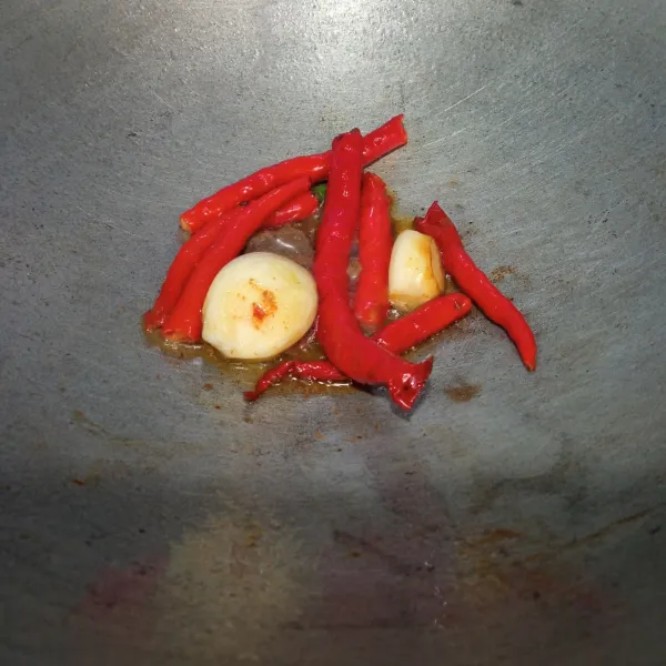 Goreng cabai merah, bawang putih, dan terasi, lalu angkat masukkan ke dalam ulegan.