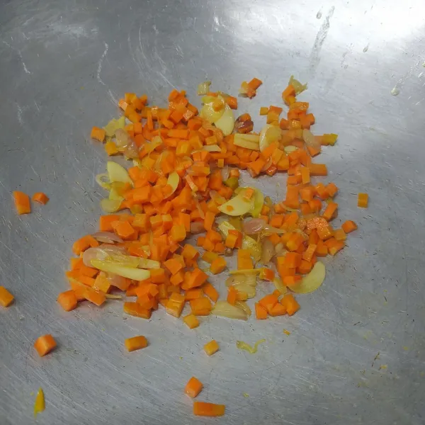 Masukkan wortel, tumis sebentar sampai ½ matang, lalu sisihkan ke tepi wajan.