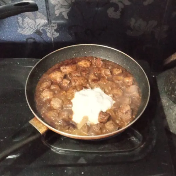 Masukkan santan, lalu aduk rata. Kemudian kecilkan api.