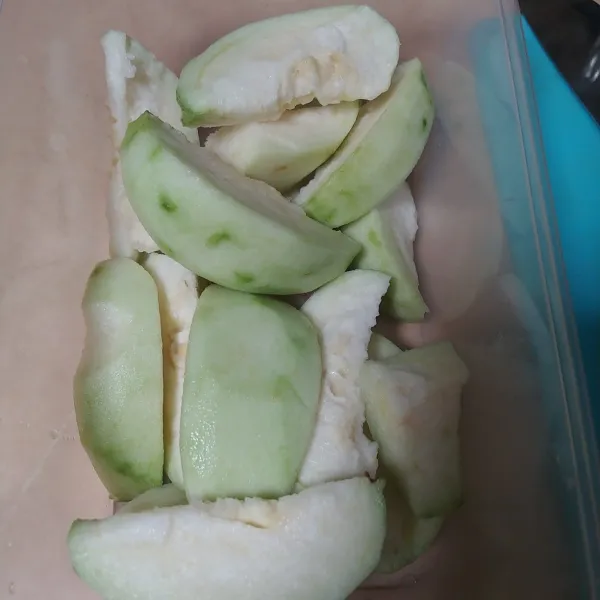 Siapkan wadah yang ada tutupnya, lalu masukkan potongan buah jambu.