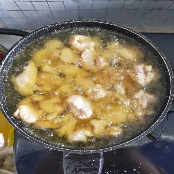 Panaskan minyak dengan api sedang, dilakukan dengan 2x proses penggorengan. Jika minyak sudah panas goreng ayam selama 3 menit, tujuannya supaya bagian dalam matang dan juicy. Setelah matang, angkat dan dinginkan.