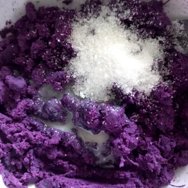 Haluskan ubi ungu menggunakan garpu, lalu tambahkan susu kental manis. Uleni adonan sampai tercampur rata.