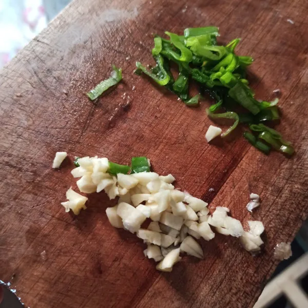 Rajang halus bawang putih dan daun bawang.