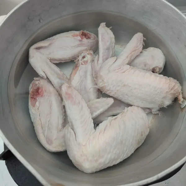 Cuci bersih sayap ayam, kemudian rebus hingga empuk.