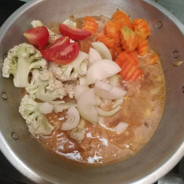 Masukkan wortel, kembang kol, tomat dan bawang bombay. Biarkan matang.