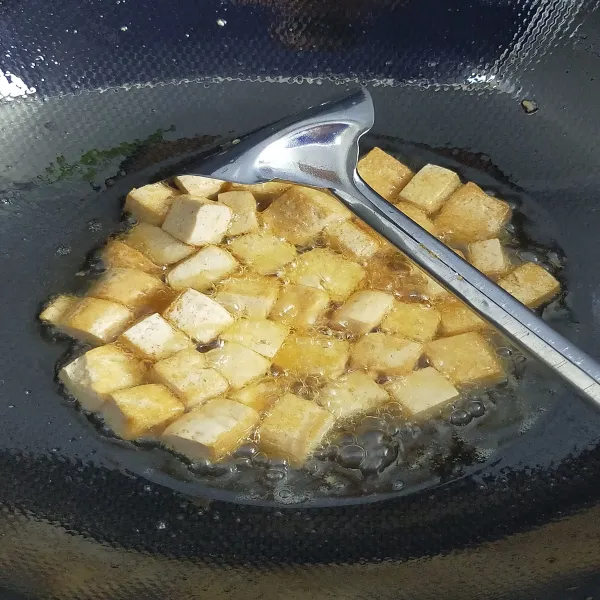 Potong tahu berbentuk kotak kecil, lalu goreng setengah matang.