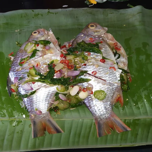 Ratakan sisa bumbu iris di atas ikan.
