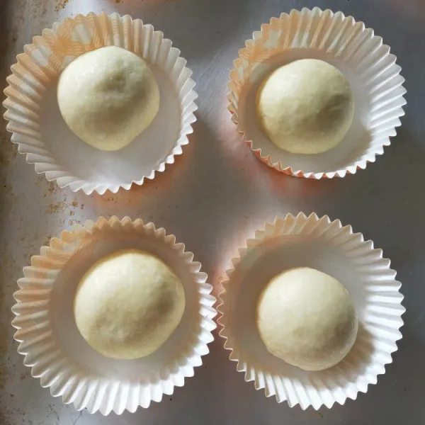 Ambil 1 dough, bulatkan lalu rounding. Tata di cup case bulat. Lakukan pada semua dough. Tutup serbet bersih, diamkan selama 40-60 menit.