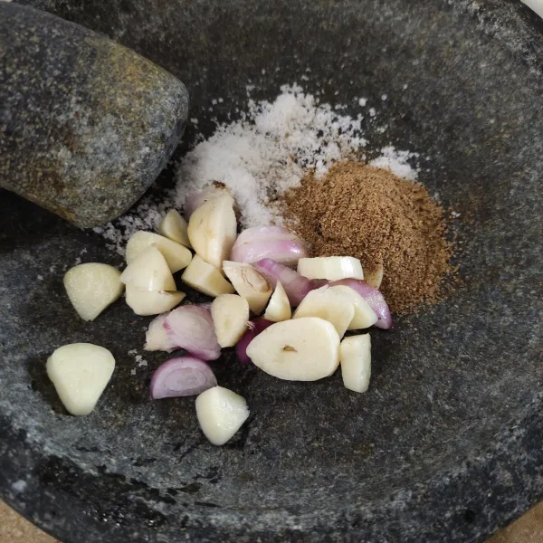 Haluskan bawang merah, bawang putih, garam dan ketumbar dengan ulekan.