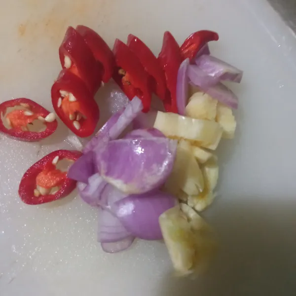 Iris agak tebal bawang merah, cacah bawang putih, iris menyerong cabai merah. Untuk cabai rawit boleh tidak dikasih.