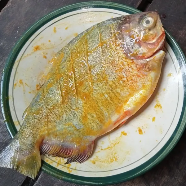 Marinasi ikan dengan bumbu hingga merata.