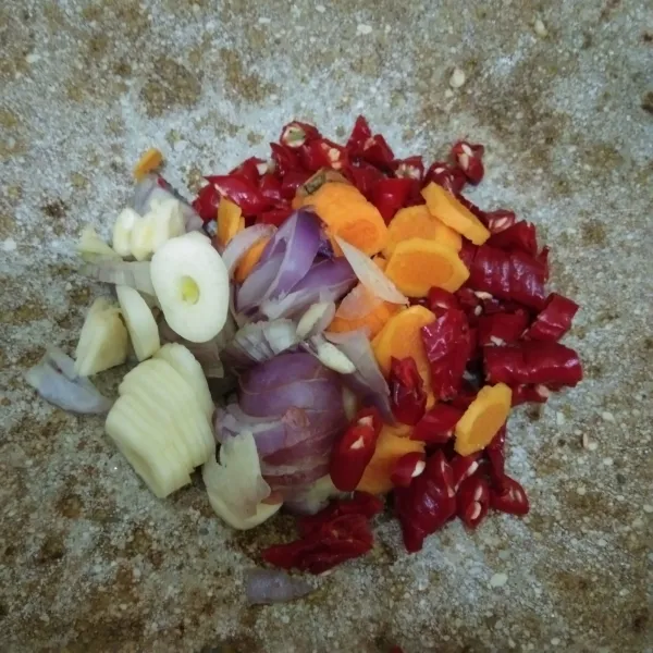 Haluskan bawang merah, bawang putih, kunyit, cabai merah keriting, dan kemiri sangrai.