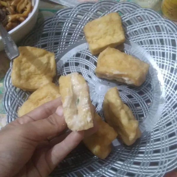 Belah bagian tengah tahu, lalu masukkan isian.