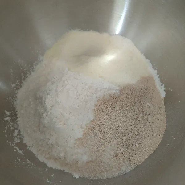 Masukkan tepung, ragi, gula pasir dan susu bubuk dalam satu wadah, aduk selama krang lebih 1 menit.