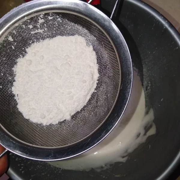 Masukkan tepung terigu sambil diayak.