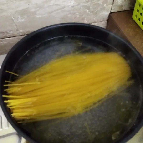 Didihkan air, beri sedikit minyak goreng dan garam. Rebus spaghetti sampai aldente.